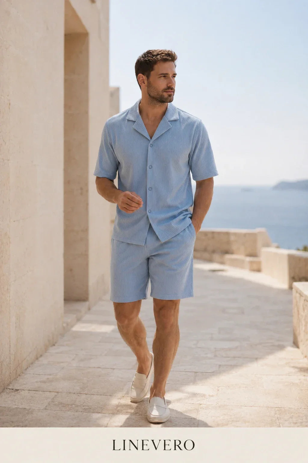 Modello che indossa il Portofino Summer Set™ Blu con naturale eleganza e una mano in tasca. L'immagine evidenzia il design italiano, il tessuto premium traspirante e la raffinata tonalità blu ispirata allo stile delle coste mediterranee.